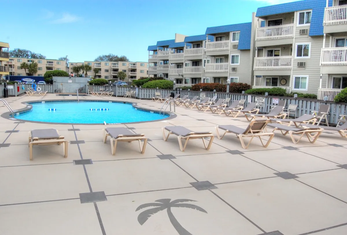 A sparkling swimming pool surrounded by loungers and nearby resort buildings sets the scene for relaxation and fun after a day out. The atmosphere is leisurely, highlighting a key amenity for unwinding together.